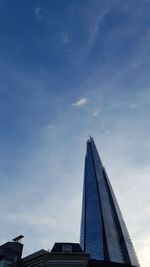 Low angle view of office building against cloudy sky