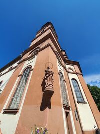 Low angle view of statue on building against sky