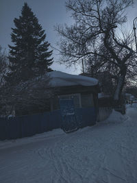 House on snow covered field against sky