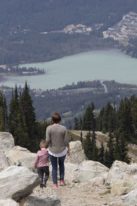 Full length rear view of boys walking on lake