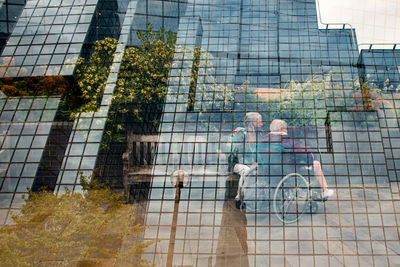 People walking on modern glass building in city