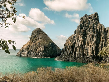 Panoramic shot of rocks in sea against sky