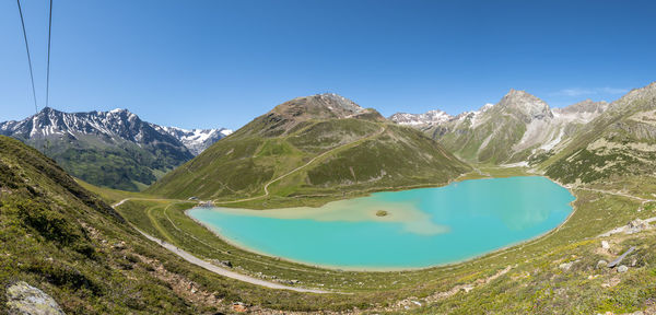 Panoramic view of lake and mountains against clear blue sky