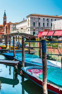 Boats moored in canal against buildings