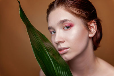 Close-up of young woman against wall