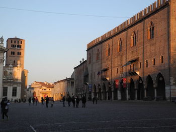 People walking on street against buildings in city