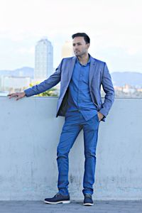 Full length of well-dressed man standing on building terrace