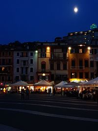 Group of people on road against buildings at night