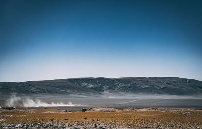 Scenic view of snowcapped mountains against clear blue sky
