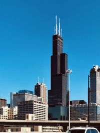 Modern buildings in city against clear blue sky