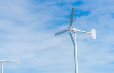 Low angle view of windmill against blue sky