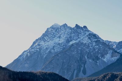 Low angle view of snowcapped mountains against clear sky