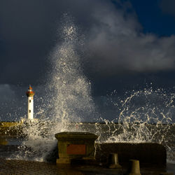 Water splashing in sea against sky at night