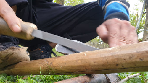 Midsection of man working on wood