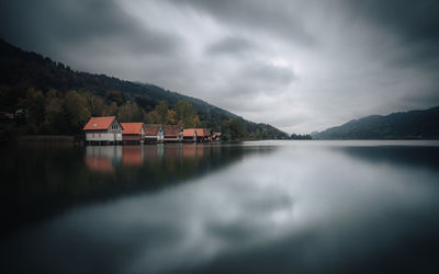 Scenic view of lake by buildings against sky