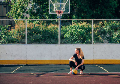 Full length of young woman playing soccer on field