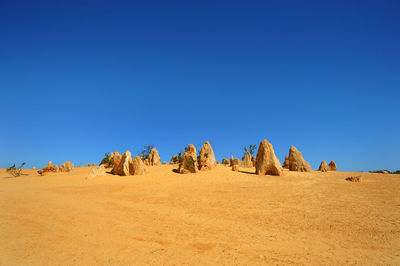 Scenic view of desert against clear blue sky