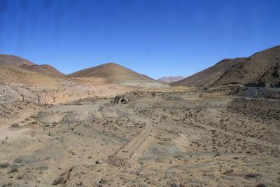 Scenic view of desert against clear blue sky