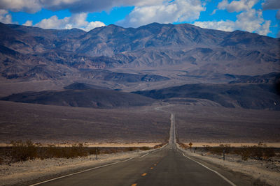 Empty road leading towards mountains