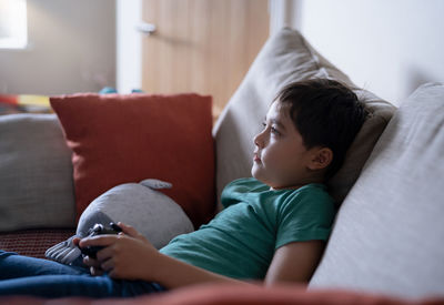 Boy sleeping on bed at home