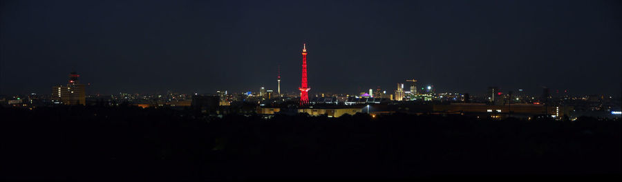 Illuminated buildings in city against sky at night