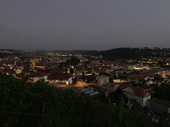 High angle view of illuminated city against sky at dusk