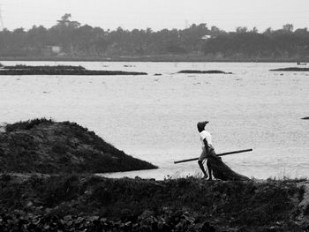 Side view of a man overlooking calm lake