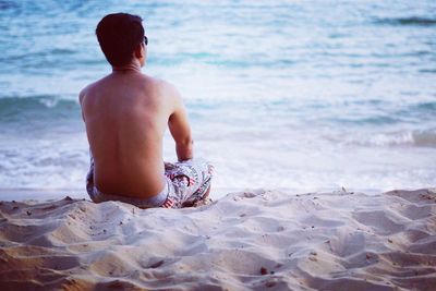 Rear view of shirtless man in sea