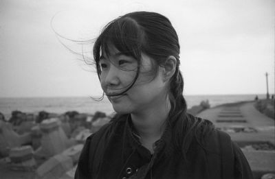 Portrait of young woman standing at beach