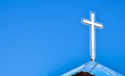 Low angle view of cross against clear blue sky