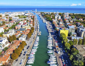 Aerial view of town by sea against sky