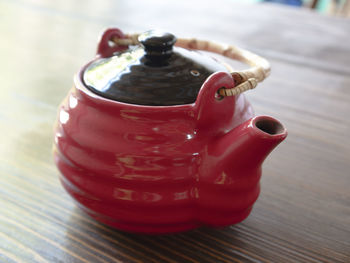 The red chinese teapot on a wooden table