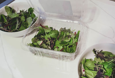 Freshly washed mixed greens are organic and contain kale, chard and spinach in bowls ready to serve