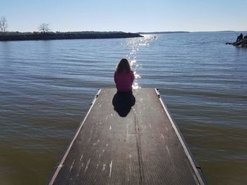 Rear view of woman on sea against clear sky