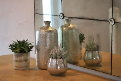 Close-up of glass jar on table against wall