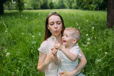 Young woman mom and son play in nature, spend time together and have fun
