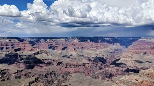 Scenic view of rock formations against cloudy sky