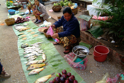 High angle view of woman sitting at market stall