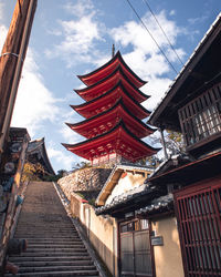 Low angle view of pagoda amidst buildings against sky