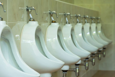 Toilet bowls mounted on wall in public restroom