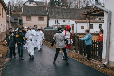 People walking on street against buildings in city