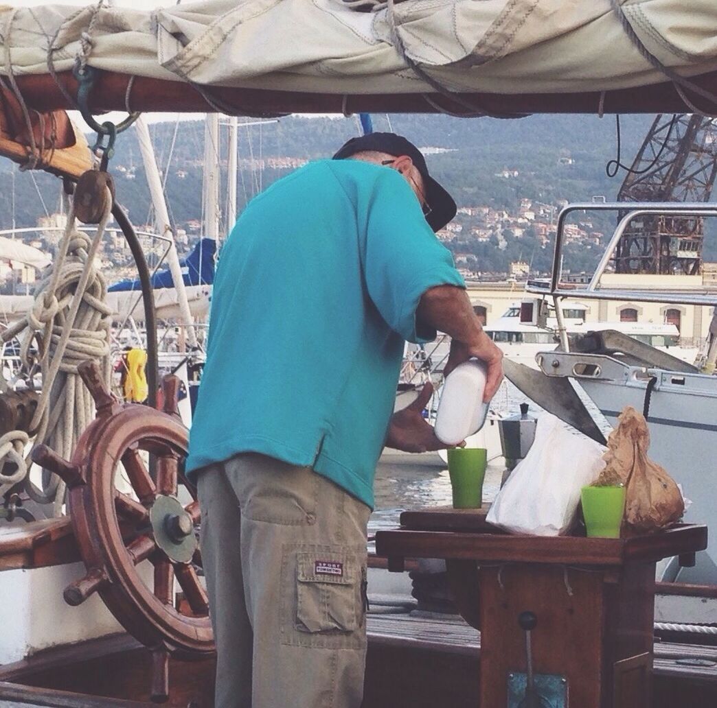 mode of transport, transportation, nautical vessel, lifestyles, men, sitting, leisure activity, casual clothing, occupation, water, day, working, boat, rear view, outdoors, holding, sea