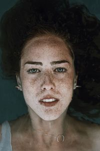 Close-up portrait of smiling young woman swimming in lake