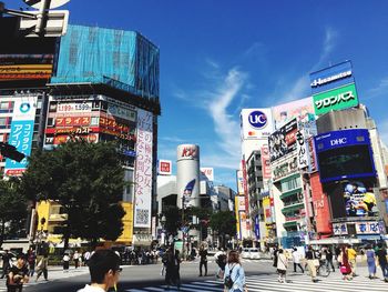People walking on road against buildings in city