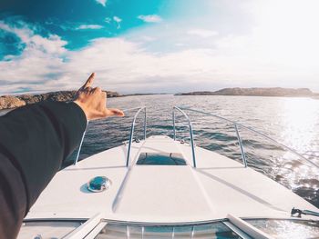 Close-up of man sailing on sea against sky