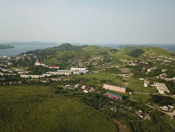 Scenic view of field by buildings against sky