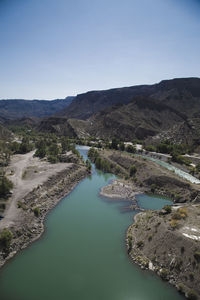 High angle view of lake and mountains against clear sky