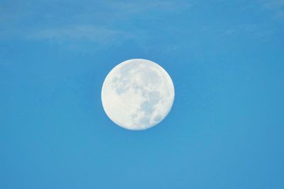 Low angle view of moon against clear blue sky