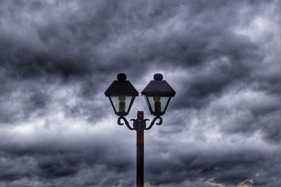 Low angle view of street light against cloudy sky