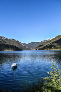 Scenic view of lake against clear blue sky